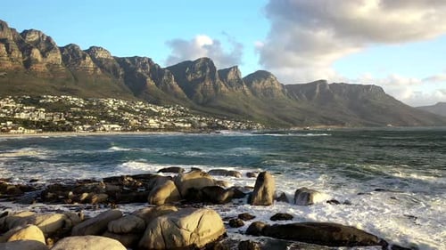 Cinematic Pull Away Shot of Cape Town's Camps Bay Beach with Table Mountain in the Background at Sun