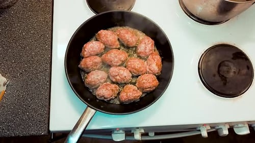 Blick von oben auf schwedische Fleischbällchen in Butter auf einer Bratpfanne. Essensrezept Schweinefleisch