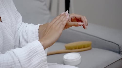 Woman Applies Moisturizing Cream to Hands Indoors