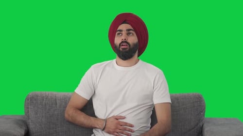 Sick Sikh Indian man suffering from stomach pain Green screen