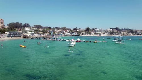 Pessoas remando na praia de Pejerrey em um dia ensolarado em Algarrobo, Chile. aéreo, largo