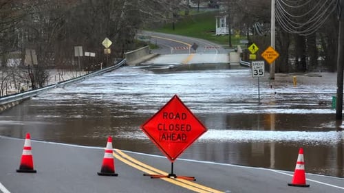 Road closed ahead sign with flooded bridge after heavy rainfall in USA. Natural disaster theme. Stat
