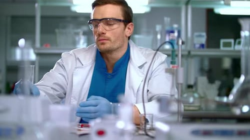 Focused scientist works in lab, conducts experiment