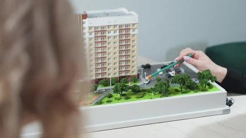 Real Estate Agent Explaining Housing Model During Client Consultation