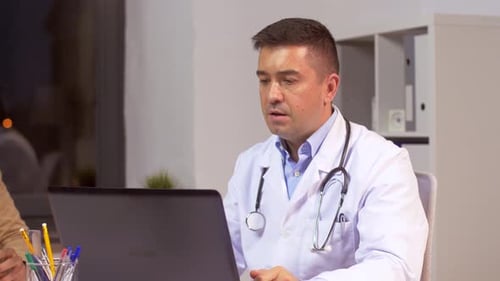 Doctor with laptop explains bad diagnosis to upset patient at city hospital