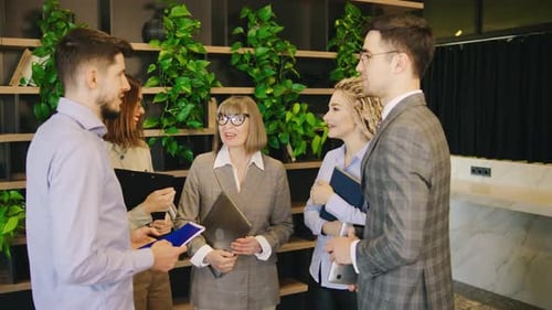 In a Vibrant and Modern Office Space a Diverse Group of Professionals is Deeply Engaged in a