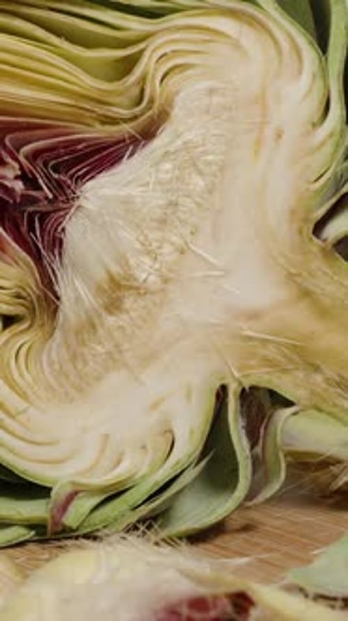 Vertical video. Man Prepares an Artichoke, Trimming Everything Unnecessary and Leaving the Tastiest