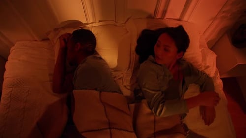 Asian Woman and Black Man are Trying to Fall Asleep in a Noisy Apartment Snoring