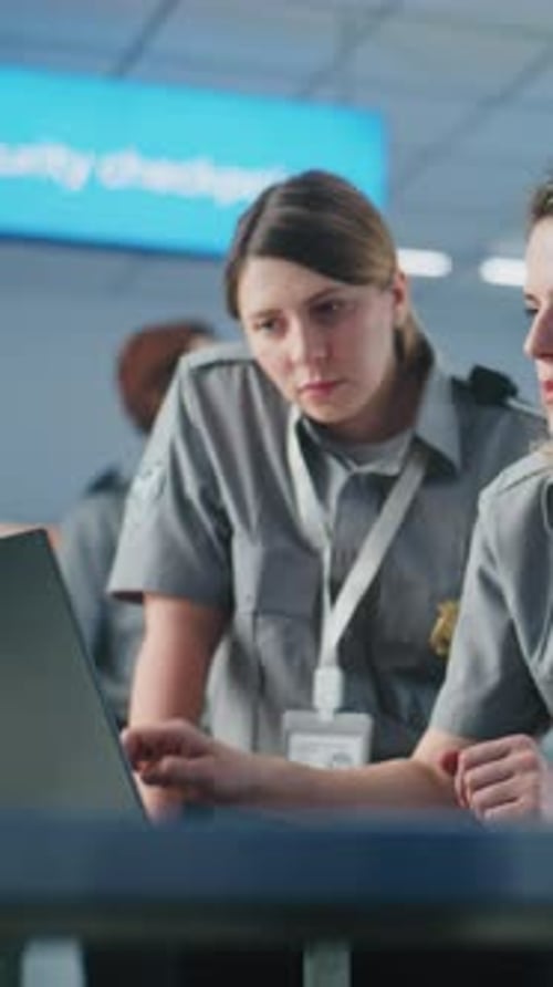 Airport Security Checkpoint Two Female TSA Officers in Headset Using Laptop Computer and Talking