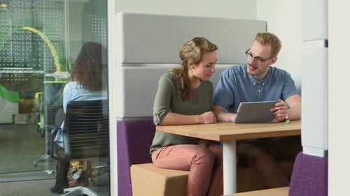 Business people discussing with tablet in office