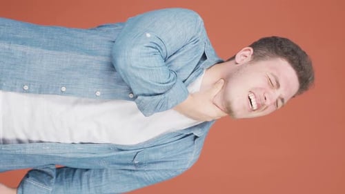 Man Coughing and Clutching Sore Throat in Vertical Shot