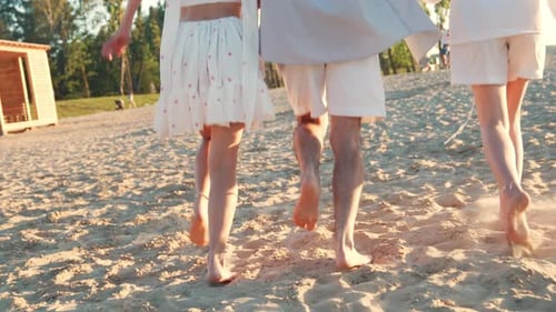 Man and two girls run at the beach
