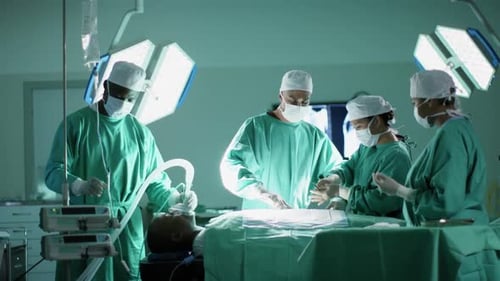 Diverse male and female surgeons operating on patient in operating theatre at hospital, slow motion