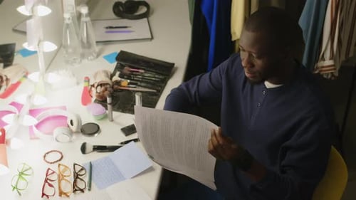 Actor Reviews Script at Lighted Dressing Room Table
