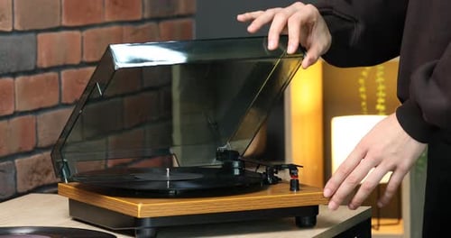 Hands Opening Record Player and Adjusting Needle