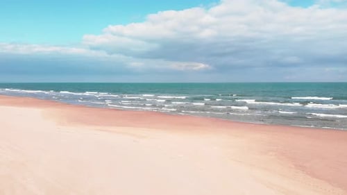 Sea waves breaking on sand beach