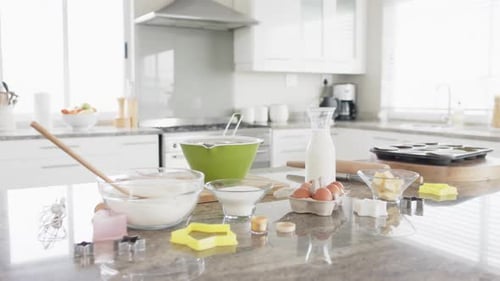 General view of kitchen with baking ingredients and equipment on countertop, slow motion