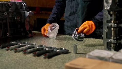 Close Up At the Service Station on the Table Young Engine Repairman Prints Out a New Part for the