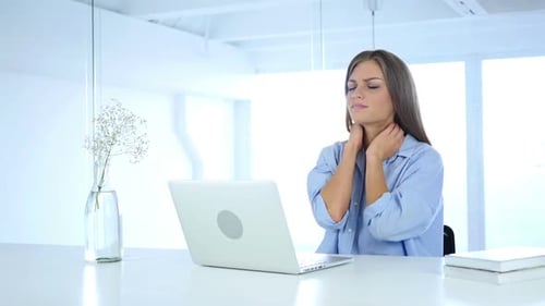 Woman Massaging Neck While Working on Laptop