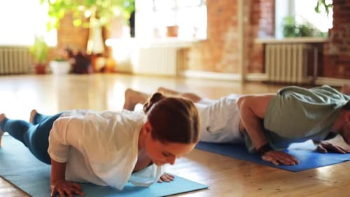 Adults Doing Yoga Poses on Mats Indoors
