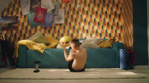 Teenager Working Out at Home with Medicine Ball