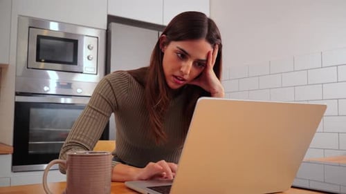 Woman Uses Laptop at Kitchen Table