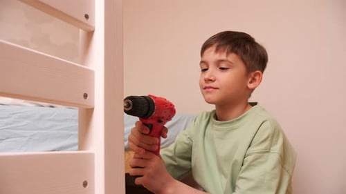 Boy Using Drill to Assemble Bed Frame