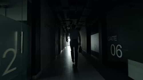 Businessman Walking Down Office Hallway