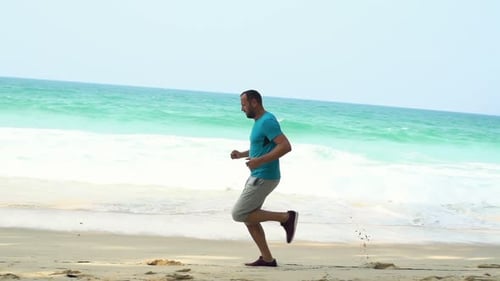 Man Jogging On Beach Near Sea