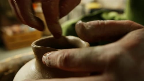 A pot in the shape of a heart is ready at the pottery workshop on the pottery wheel