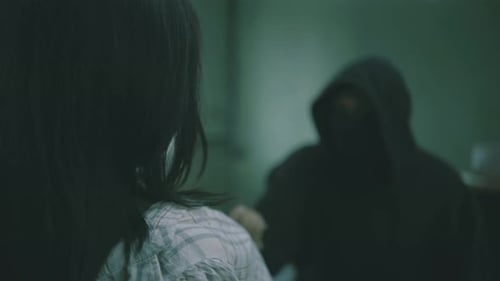 The criminal puts a knife to his throat, tied in the basement to a young woman.