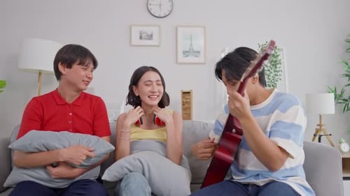 Friends Relaxing and Playing Guitar at Home