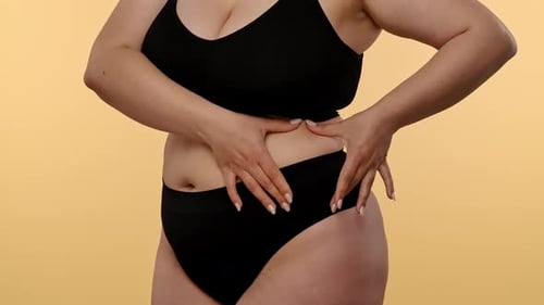 Femme en sous-vêtements vérifiant la texture de la peau sur son ventre