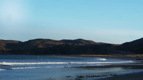 A Bay with Large Waves on the Shore of a Northern Country Surrounded By Huge Hills and Rocky Cliffs