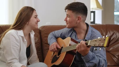 Young Man Playing Guitar for a Friend