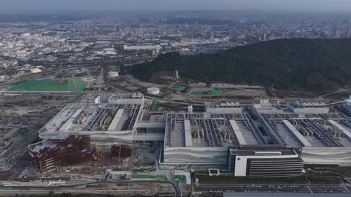 Aerial drone view of a sprawling semiconductor manufacturing complex and new construction beside an