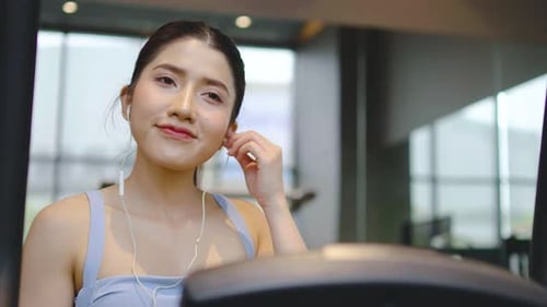 Woman Exercising on Elliptical Machine at the Gym