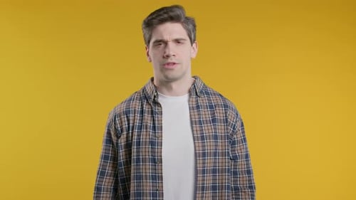 Man Shakes Head No on Yellow Background