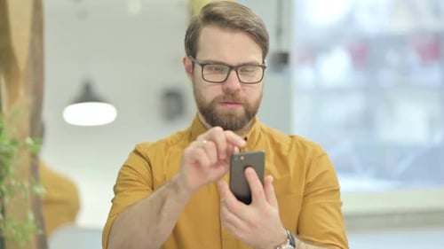 Junger Mann nutzt Smartphone zum Surfen im Internet