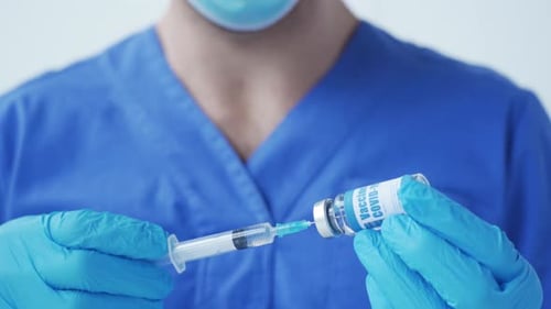 Medical Professional Drawing Vaccine Into Syringe