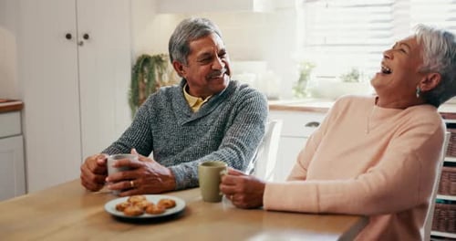 Senior Couple Chatting Over Coffee in Kitchen