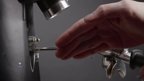 Barista handverdichtet gemahlene Kaffeebohnen in Filter-Nahaufnahme. Unbekannter Mann nivelliert