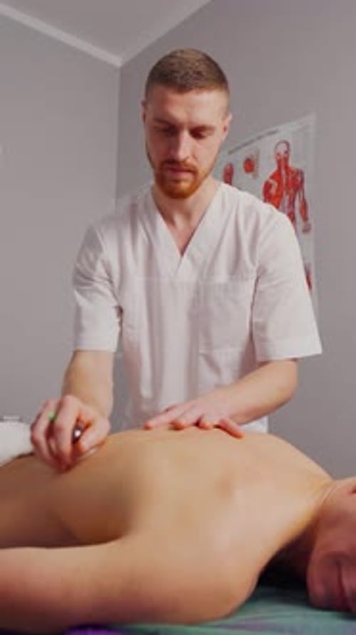 Male Masseur Doing Acupuncture Therapy to Man in Spa Salon Cupping therapyVacuum Massage of Patient
