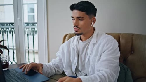 Young Man Using Laptop for Video Call at Home