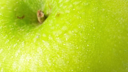 A green apple with droplets of water. macro video.