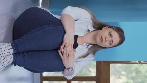 Woman Sitting on Floor Hugging Knees Looking Sad