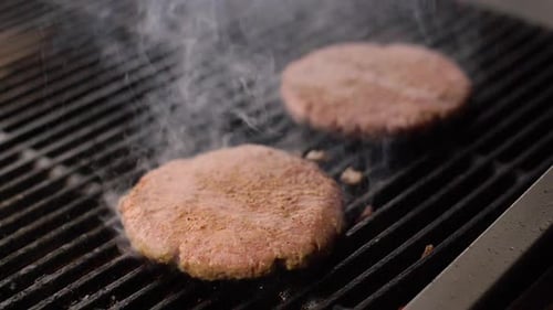 Chef Cooking Beef Patty for Burger on Hot Grill and Flip the Cutlet with a Spatula