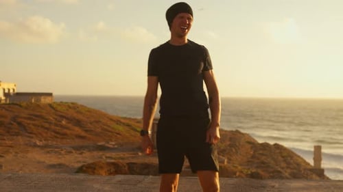 Active Sporty Man Jumping While Training with Elastic Ropes By Sea