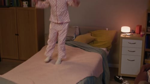 Happy Girl Jumping on Bed with Headphones