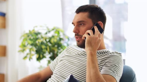 Man Talking on Phone Sitting at Home